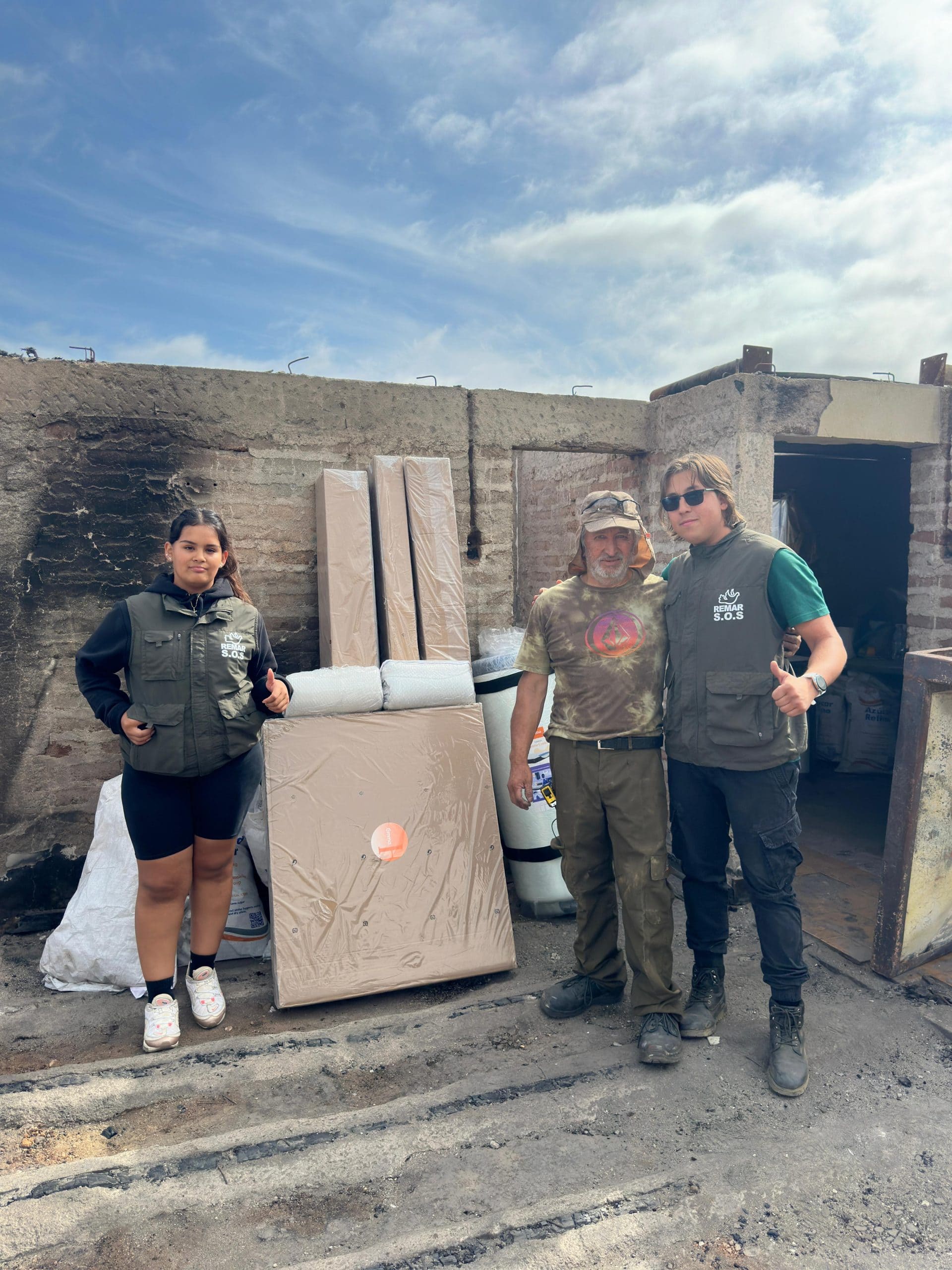 Voluntarios de Remar S.O.S junto a colchones y artículos recibidos como donación